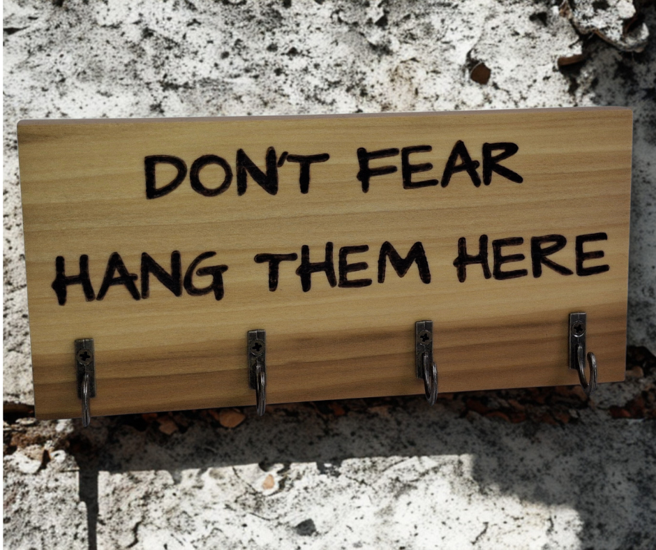  four-hook hanger crafted from two-tone Tulipwood, featuring hand-burnt lettering that reads "Don't Fear Hang Them Here." The wood has visible grain, showcasing its natural variations.