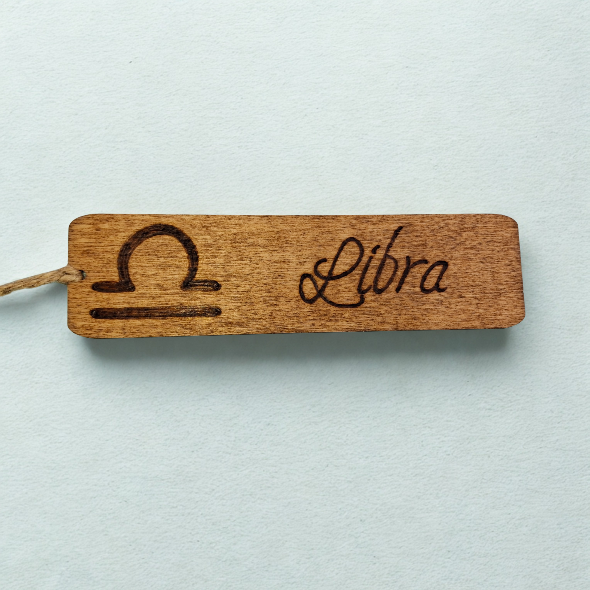 Dark wood bookmark with "Libra" pyrography and a star sign illustration.
