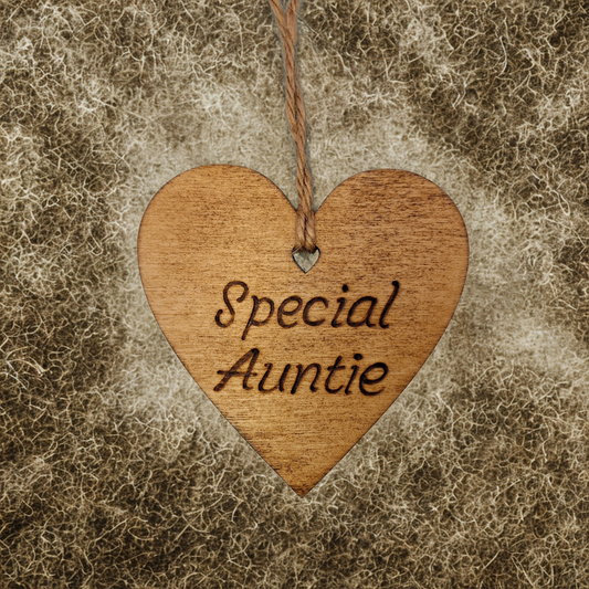 A small, possibly 8cm by 8cm, light-colored wooden heart, decorated with "Special Auntie" hand-burned into its surface using pyrography. A short length of natural jute rope is tied through the top for hanging.