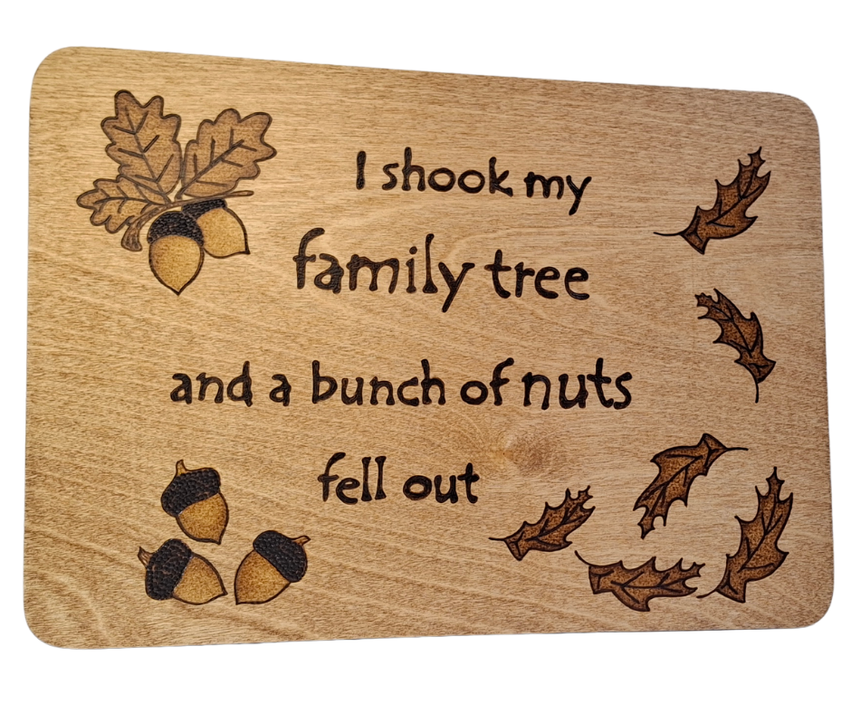 Wooden plaque hand-decorated with "I shook my family tree and a bunch of nuts fell out" pyrography and acorn illustrations