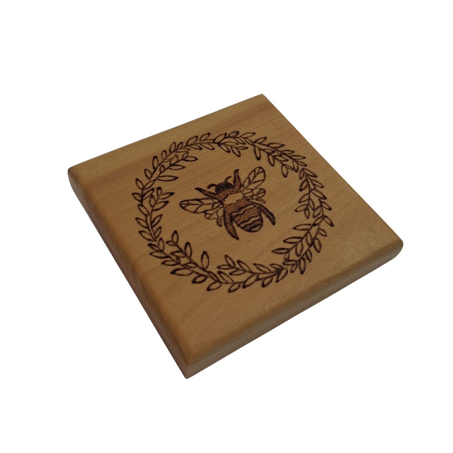 Wooden coaster with hand burnt bee and leaf design on a white background