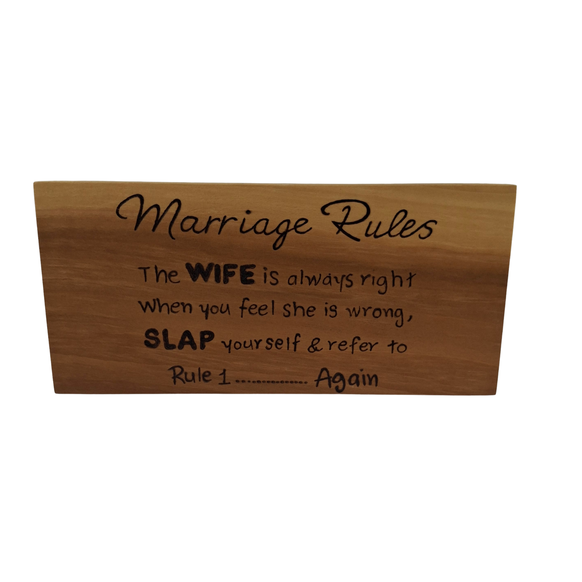 Wooden sign with humorous 'Marriage Rules' text on a white background