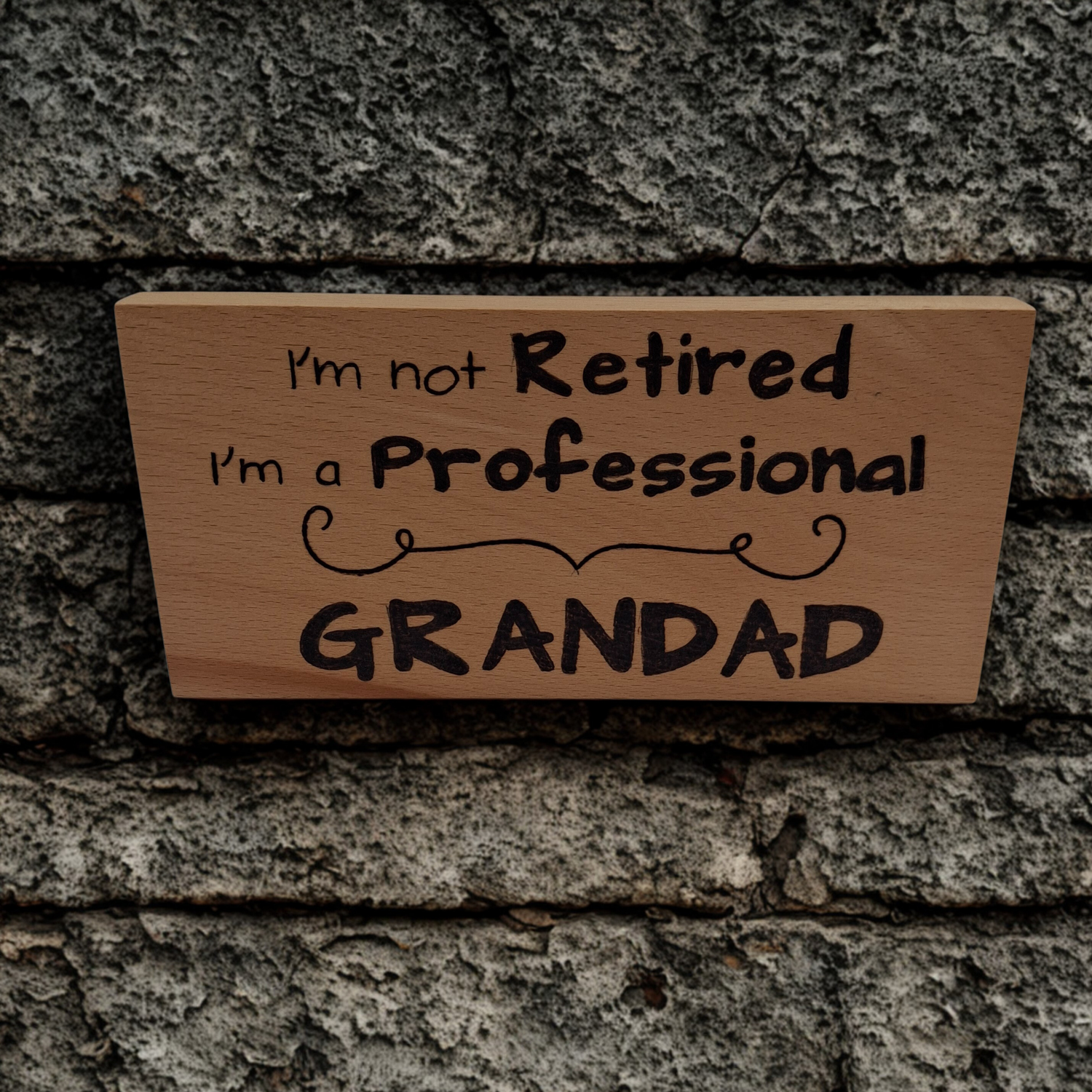 Wooden sign with text 'I'm not retired, I'm a professional grandad' hand burnt 