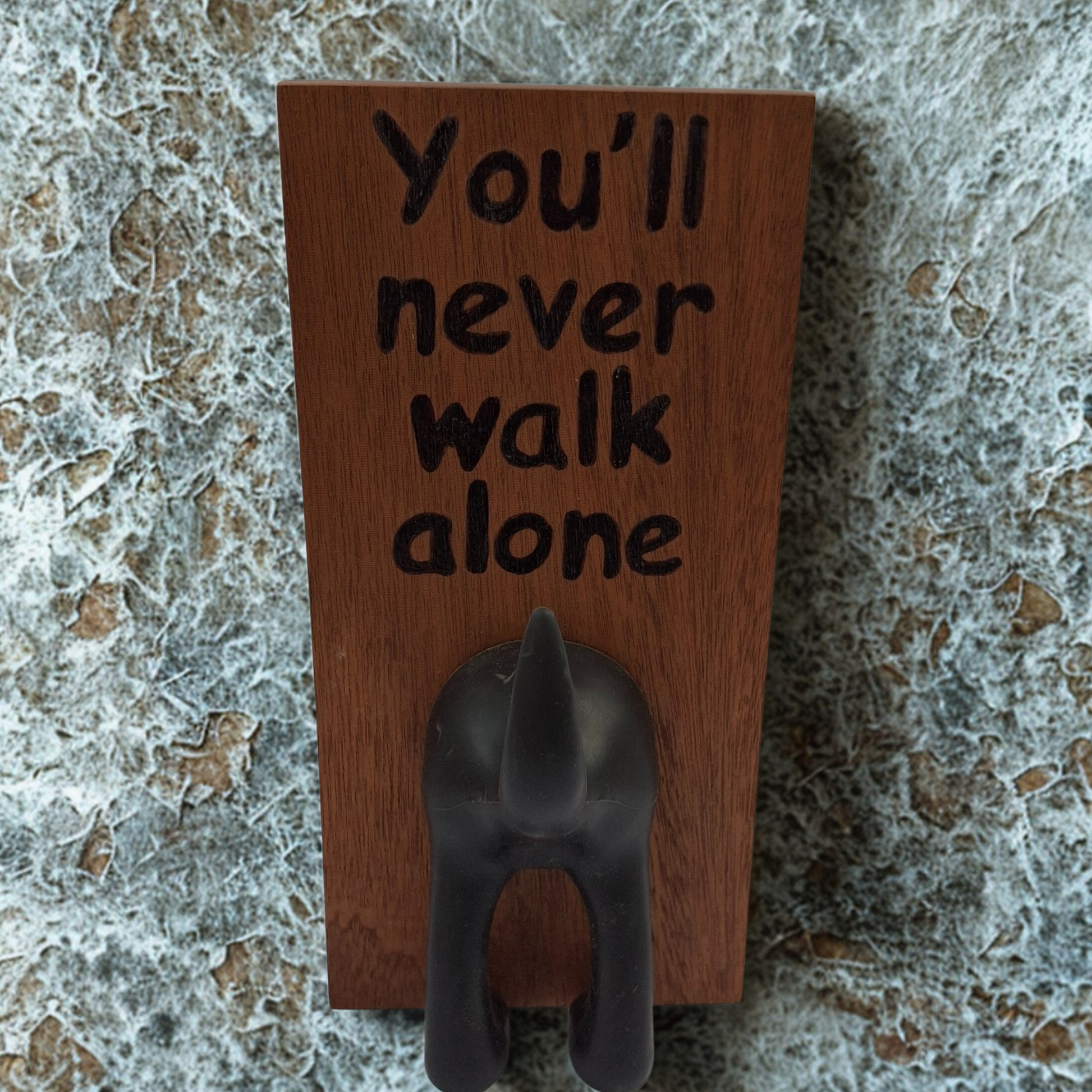 Dark wooden plaque with a rubber dog tail for hanging leads, You'll never walk alone hand burnt into the wood
