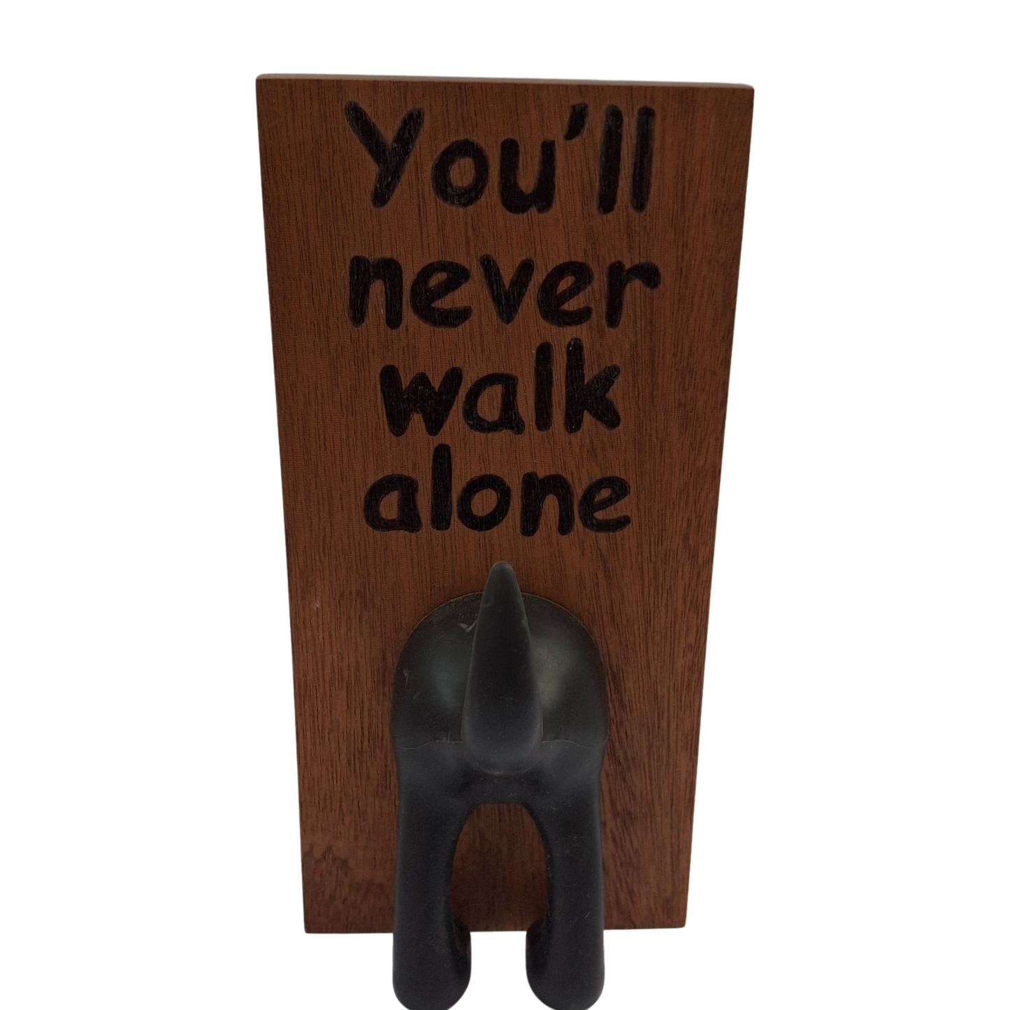 Wooden plaque with 'You'll never walk alone' text and a dog-shaped hook on a white background