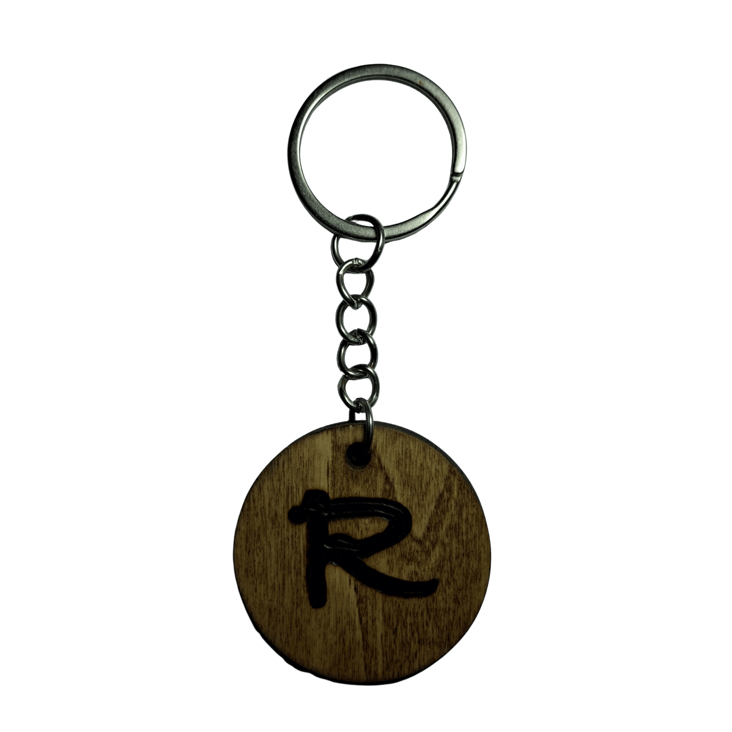 Round keyring made from veneered plywood. The letter R is hand-burnt using pyrography, finished with a hardwax oil, and attached to a silver keychain.